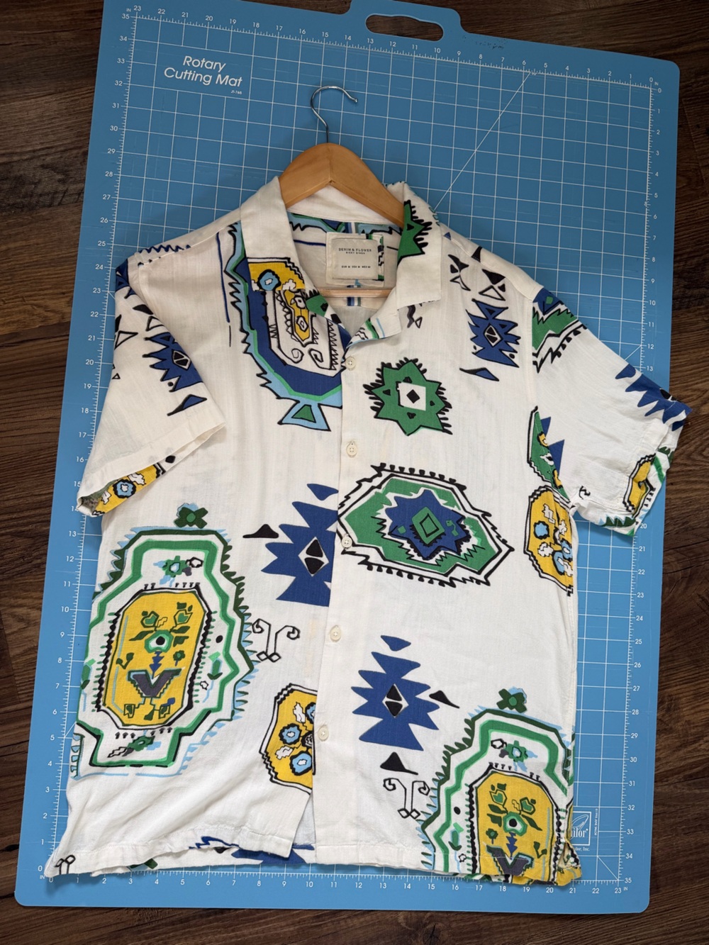 Men's Short Sleeve Button-Up Shirt in White with Green & Blue Geometric Print.